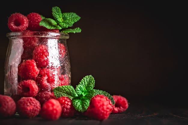 Himbeeren in einer Tasse auf dunklem Hintergrund