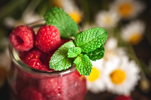 Himbeeren in einer Tasse auf dunklem Hintergrund