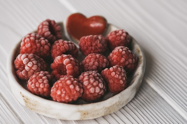 Himbeeren in kleiner Keramikschale mit rotem Herzdekor Nahaufnahme