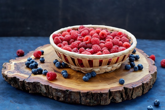 Himbeeren und Blaubeeren auf blau. Getreide.