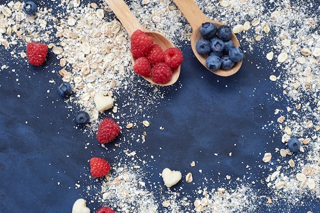 Himbeeren und Blaubeeren auf blauem Hintergrund