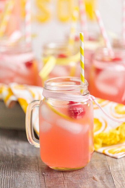 Himbeerlimonade garniert mit frischer Zitrone und Himbeeren in Trinkgläsern.