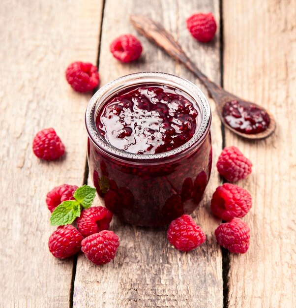 Foto himbeermarmelade mit himbeerbeeren mit minze auf holztischen gesundes lebensmittelbestandteil