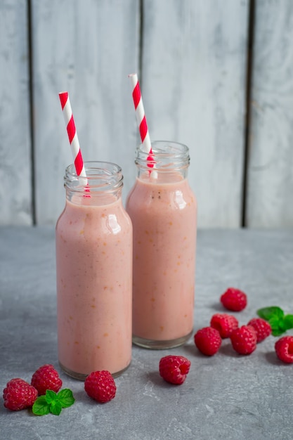 Himbeerselbstgemachter Milchshake in Flaschen und Beerenstreuung