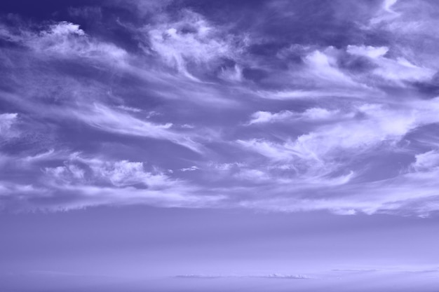 Himmel mit Federwolken, violett sehr peri Farbe, abstrakter Hintergrund.