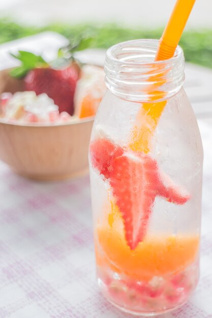 Hineingegossene Wasserflasche erfrischendes Getränk der Mischungsfrucht