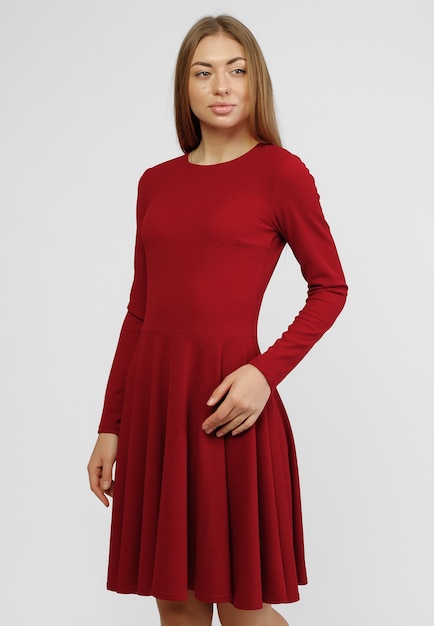 Hinreißende Frau. Porträt der schönen lächelnden jungen Frau, die im netten roten Kleid lokalisiert auf weißem Hintergrund in voller Länge steht. das Konzept der Werbung Kleider für den Laden.