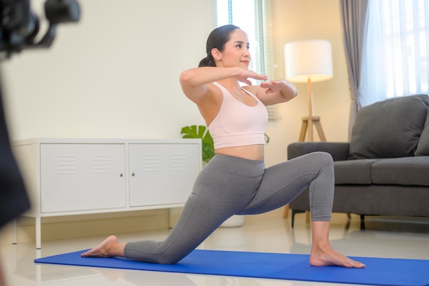 Hinter den Kulissen einer fitten jungen Frau, die zu Hause Yoga und Meditation macht