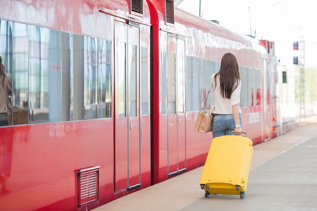 Hintere Ansicht der Frau mit Tasche an der Station, die mit dem Zug reist