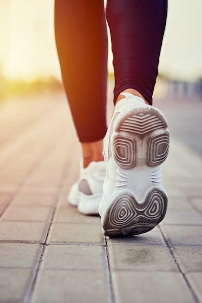 Hintere Ansicht des Läufers in den Sportturnschuhen, die draußen laufen