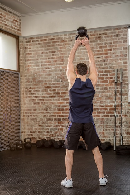 Hintere Ansicht des Mannes Kettlebell halten