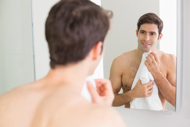 Hintere Ansicht des Mannes Selbst im Badezimmerspiegel betrachtend