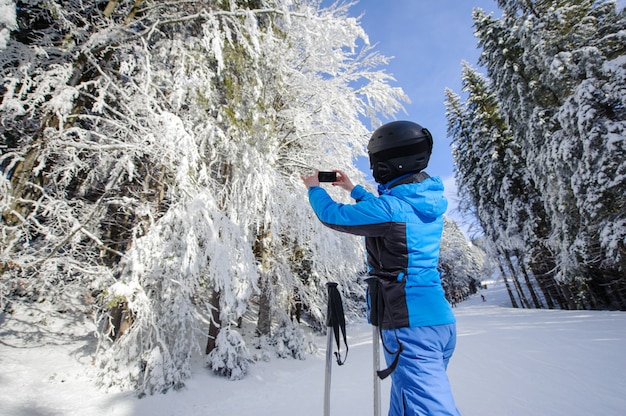 Hintere Ansicht des Skifahrers Foto mit ihrem Handy machend