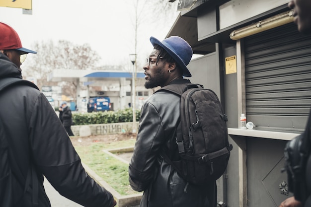 Hintere Ansicht drei junge afrikanische Männer, die zusammen in die Straße gehen