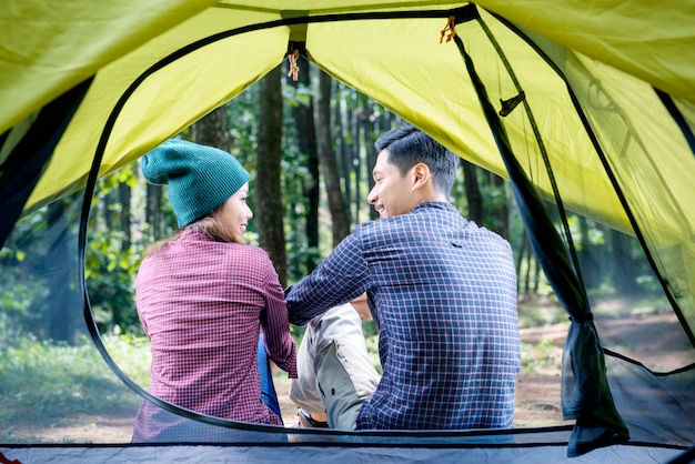 Hintere Ansicht von den asiatischen Paaren, die außerhalb des Zeltes sich entspannen
