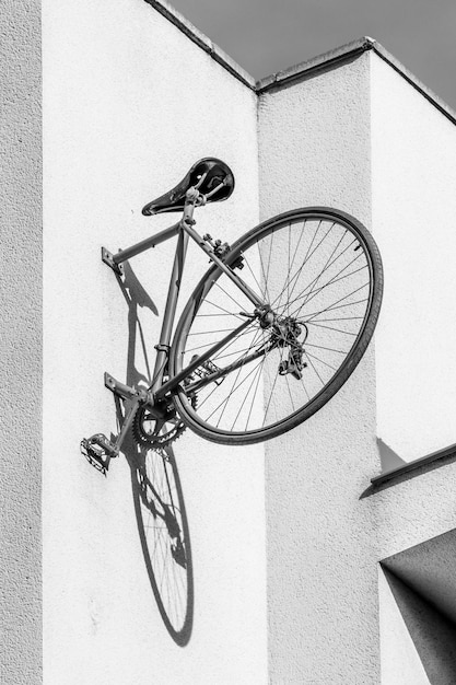 Foto hintere hälfte des roten oldtimer-fahrrads, das an der wand befestigt ist und den schatten seines rads wirft