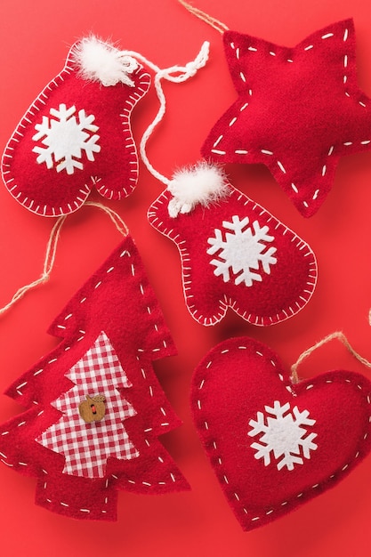 Hintergrund aus Textil-Weihnachtsbaumspielzeug auf rotem Hintergrund-Draufsicht