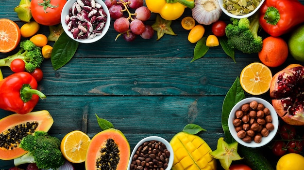 Hintergrund Bio-Lebensmittel Obst Gemüse Bohnen und Nüsse auf blauem Hintergrund Ansicht von oben Freier Platz für Ihren Text