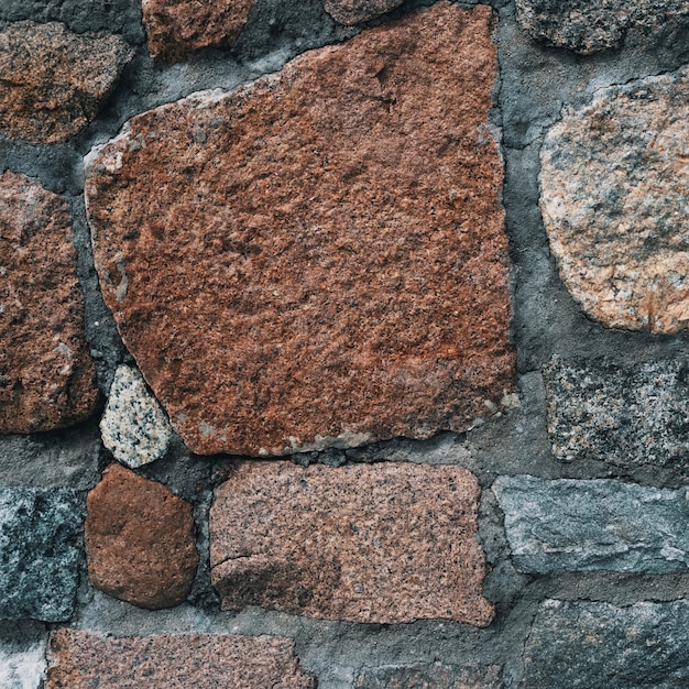 Hintergrund der alten Steinmauer mit Steinen verschiedener Größen und Farben