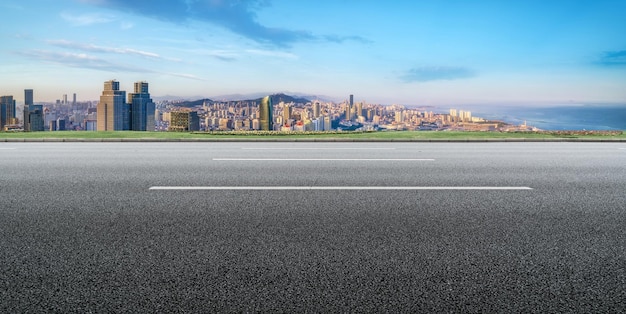 Hintergrund der Asphaltdecke und der urbanen architektonischen Landschaftsskyline