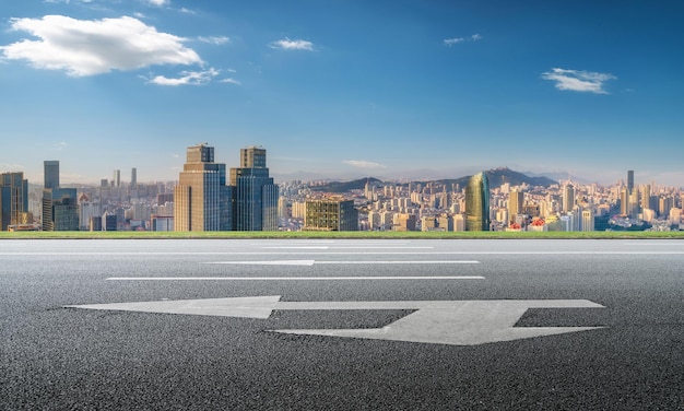 Hintergrund der Asphaltdecke und der urbanen architektonischen Landschaftsskyline