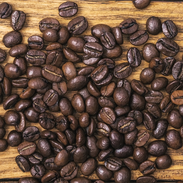 Hintergrund der gerösteten Kaffeebohnen ist braun auf Holzbrettern