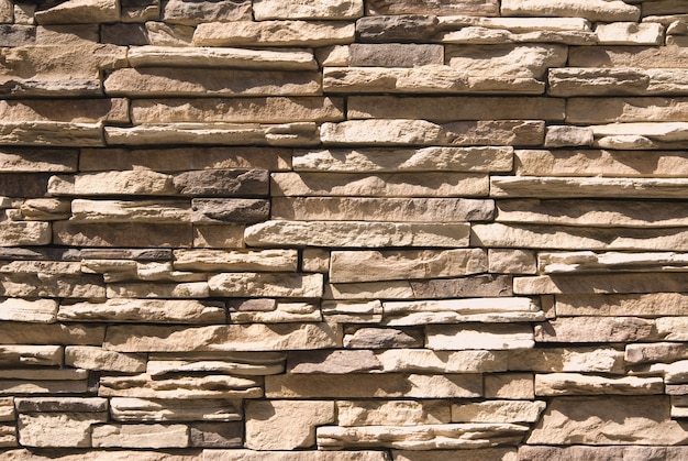 Hintergrund der künstlichen Steinmauer mit hellem Sonnenlicht und Schatten