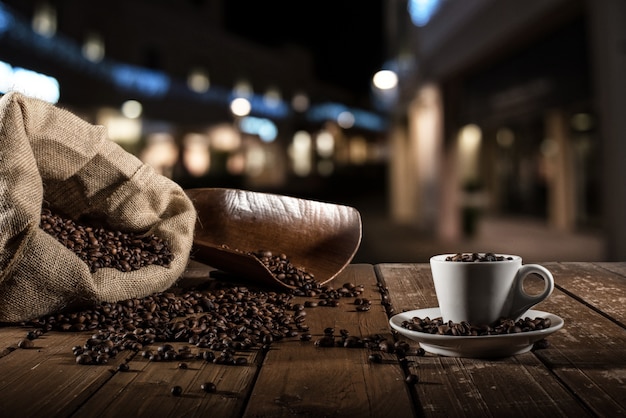 Hintergrund der Tasse Kaffeebohnen mit Jutesack und Bailer