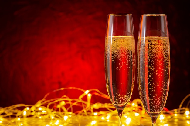 Hintergrund der Weihnachts- und Neujahrsfeiertage. Gläser Champagner und Beleuchtung mit Kopierraum.