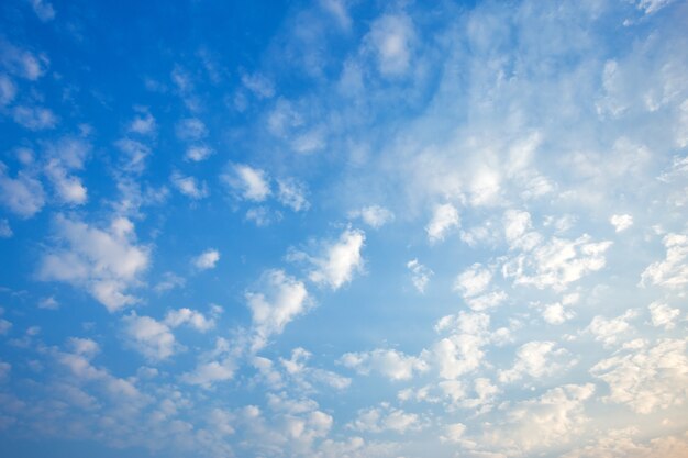 Hintergrund des blauen Himmels mit weißem Wolkensonnenuntergang.