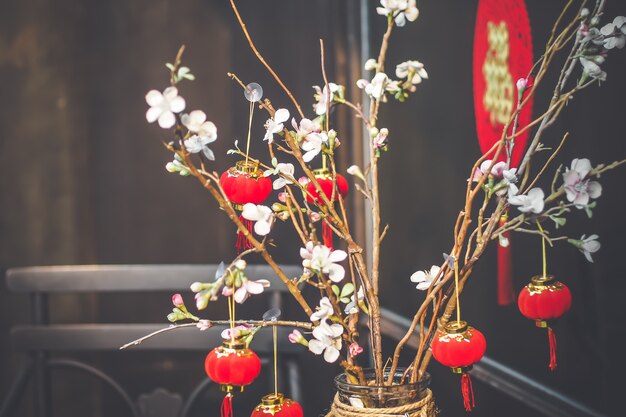 Hintergrund des Chinesischen Neujahrsfests. Rot blühende Sakura-Zweige auf hellem Hintergrund