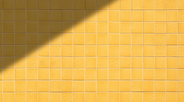 Hintergrund des gelben quadratischen Fliesenwandmusters mit Licht und Schatten auf der Oberfläche in Breitbildansicht