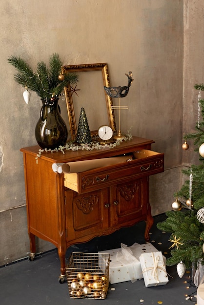 Hintergrund des neuen Jahres. Innenraum des Weihnachtsloft-Zimmers. Beleuchtung, antike Möbel, Kerzen und heiße Innenbeleuchtung, Girlanden in der Nähe des Weihnachtsbaums mit Geschenken. Weicher selektiver Fokus.