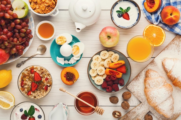 Hintergrund des reichhaltigen kontinentalen Frühstücksmenüs. Köstliches natürliches Essen für leckere Morgenmahlzeiten auf Holztisch, traditionelles europäisches Buffet