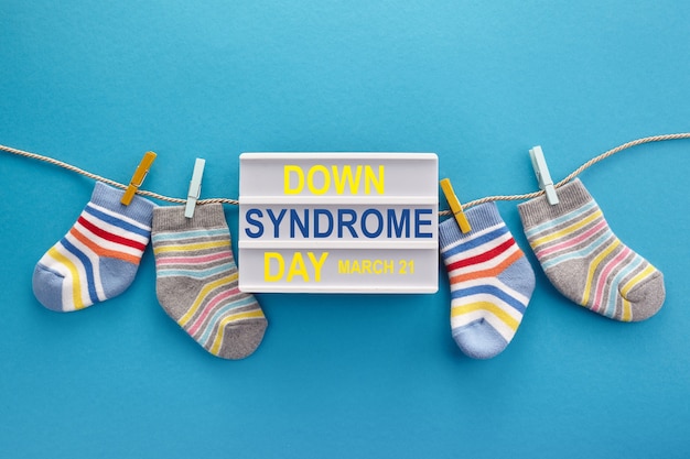 Hintergrund des World Down-Syndrom-Tages. Down-Syndrom-Bewusstseinskonzept. Socken und Leuchtkasten auf blauem Hintergrund