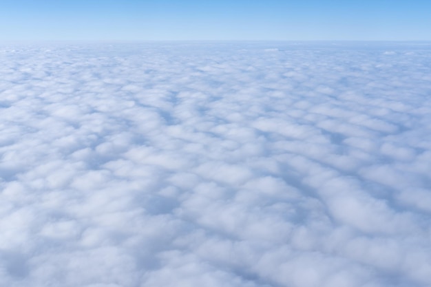 Hintergrund eines rosafarbenen, violetten Himmelshimmels mit flauschigen, dichten Wolken, Draufsicht von einem Flugzeug Sky Gradient