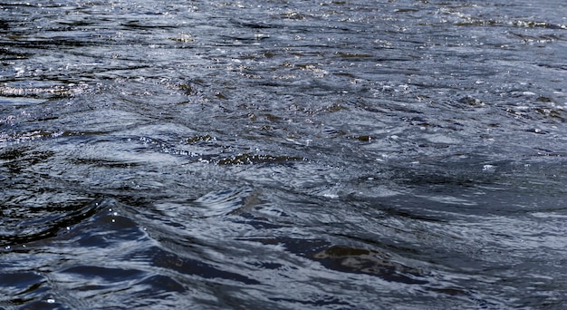 Hintergrund - Flusswasser mit Wellen und Whirlpools an einem bewölkten Tag