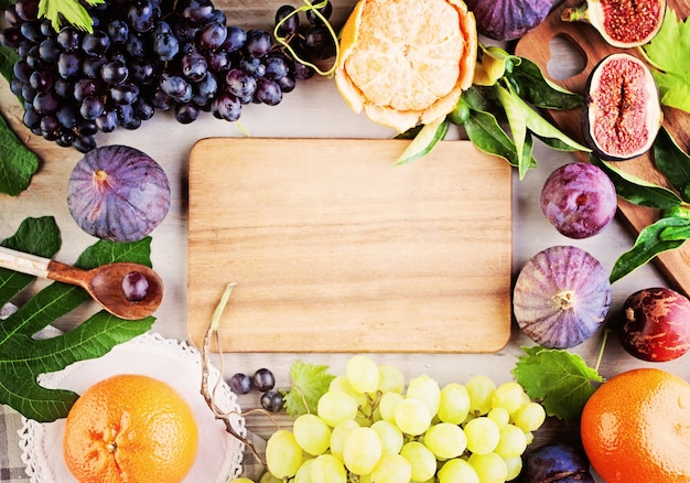 Hintergrund für gesunde Ernährung mit Bio-Früchten und braunem Holzbrett