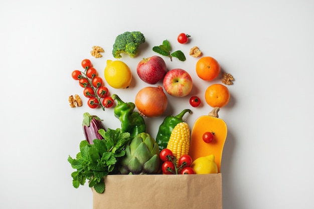 Hintergrund für gesunde Lebensmittel Gesundes veganes vegetarisches Essen in Papiertüten Gemüse und Obst auf weißem Kopierraumbanner Einkaufen im Lebensmittelsupermarkt und sauberes veganes Essenskonzept