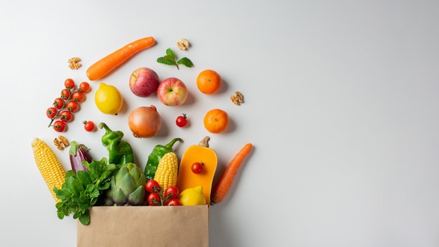 Hintergrund für gesunde Lebensmittel Gesundes veganes vegetarisches Essen in Papiertüten Gemüse und Obst auf weißem Kopierraumbanner Einkaufen im Lebensmittelsupermarkt und sauberes veganes Essenskonzept