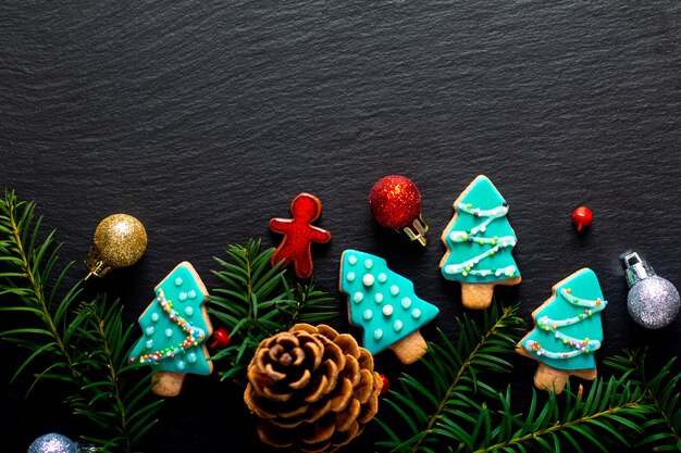Hintergrund für Pastellweihnachtsplätzchenbaum des Feiertagslebensmittels DIY auf schwarzem Schieferbrett