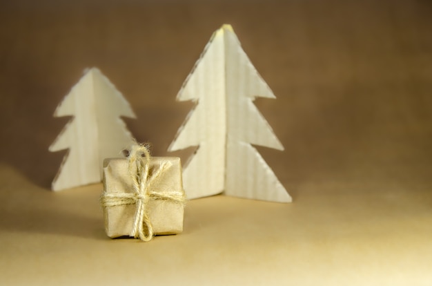 Hintergrund für Weihnachten, Neujahr. Zero Waste, umweltfreundliche Verpackung von Geschenken auf Kraftpapierhintergrund und hausgemachte Weihnachtsbäume aus Pappe, Öko-Urlaubskonzept, Öko-Dekor