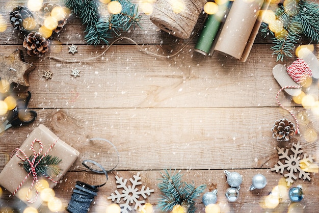 Hintergrund für Weihnachtsgeschenke mit Kraftpapier, Jute, Seil, Schere und Kiefernzweigen