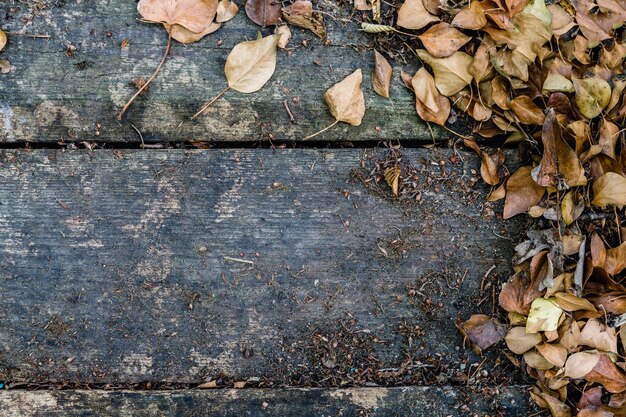 Hintergrund mit altem Holztisch und gelben herbstlichen Blättern