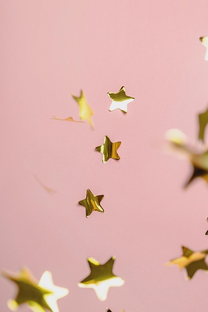 Hintergrund mit fliegenden goldenen Konfettisternen rosa Hintergrundtapete