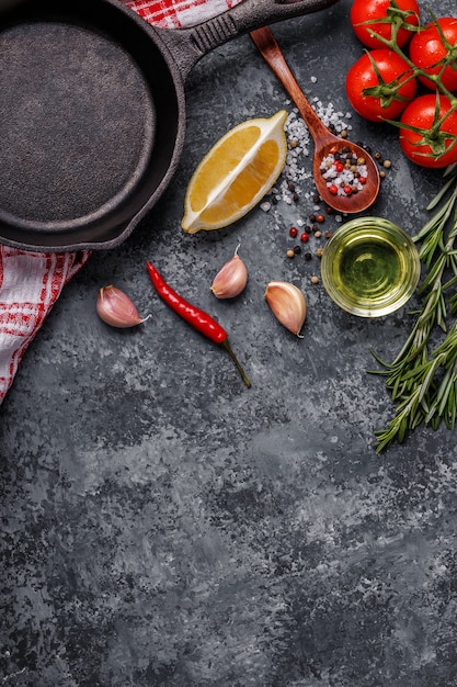 Hintergrund mit Gewürzen, Kräutern, Olivenöl und Pfanne zum Kochen.