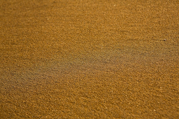 Hintergrund mit goldenem Sand an der Küste der Insel Kreta.