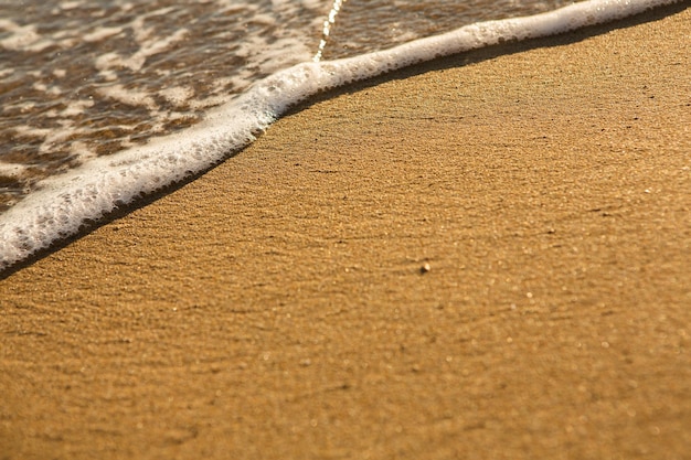 Hintergrund mit goldenem Sand an der Küste der Insel Kreta.