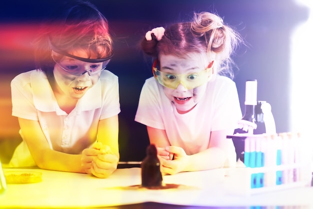 Hintergrund mit Highlights von Wissenschaftlerkindern Ein Junge und ein Mädchen experimentieren im Labor