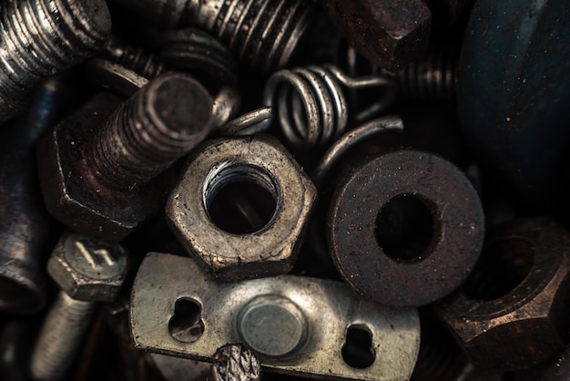 Hintergrund mit Schrauben, Schrauben und anderen Reparaturteilen in Nahaufnahmen von Metallteilen für verschiedene Reparaturen